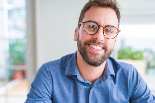 istock Handsome man wearing glasses and smiling relaxed at camera 1162410334