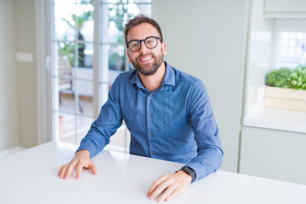 istock Handsome man wearing glasses and smiling relaxed at camera 1162410390