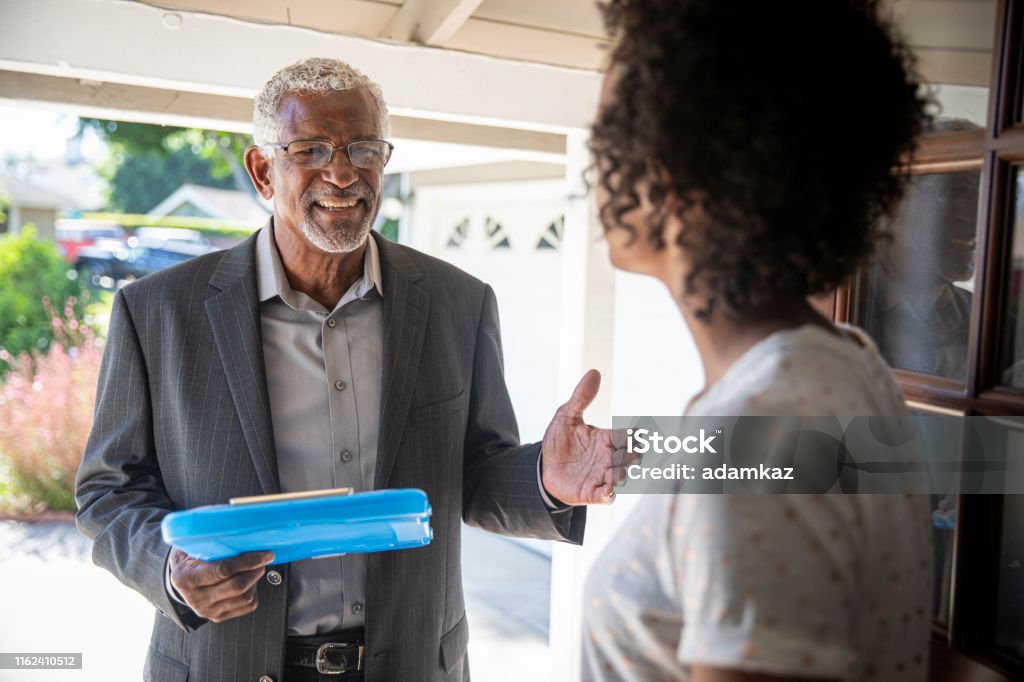 Senior Black Politician Door to Door A senior black man visits with a potential voter to earn her support. Census Stock Photo