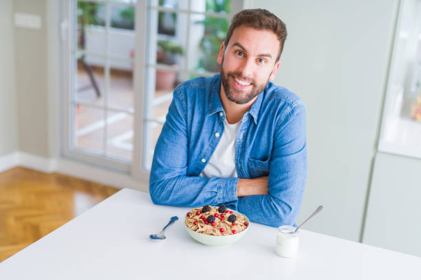 istock Handsome man having breakfast eating cereals at home and smiling 1162410578