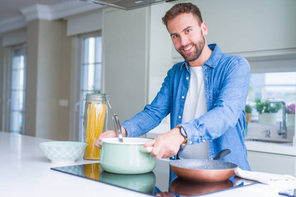 istock Handsome man cooking pasta at home 1162410603