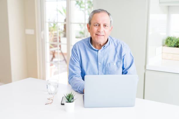istock Handsome senior man using laptop and smiling 1162413130