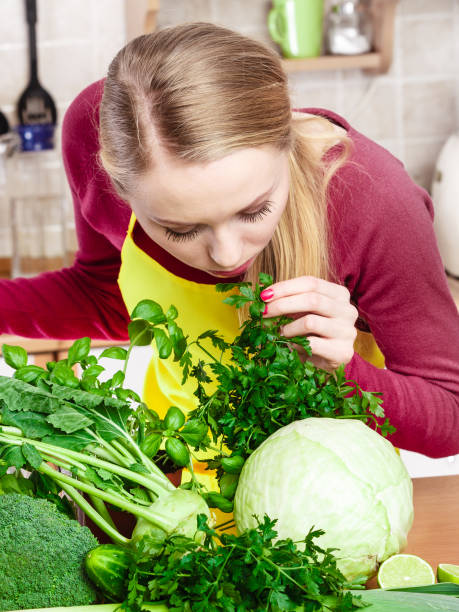 istock Woman in kitchen having many green vegetables 1162414954