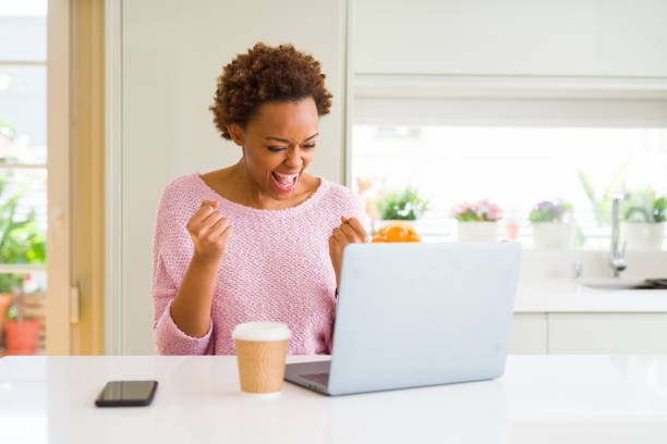 istock Young african american woman working using computer laptop very happy and excited doing winner gesture with arms raised, smiling and screaming for success. Celebration concept. 1162418517