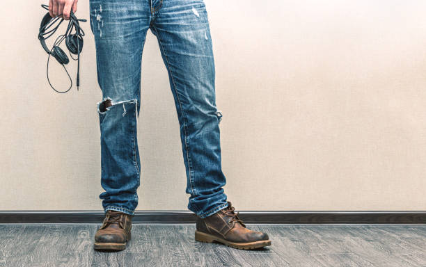 istock Man in jeans with headphones 1162419514