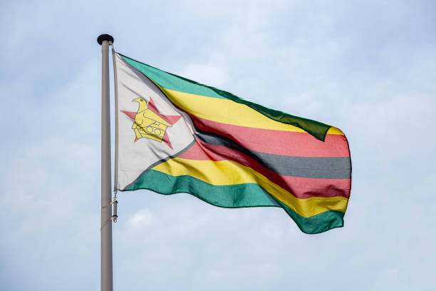 istock Zimbabwe flag waving against clear blue sky 1162419720