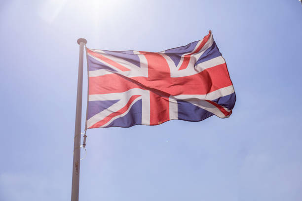 istock Great Britain flag waving against clear blue sky 1162419724