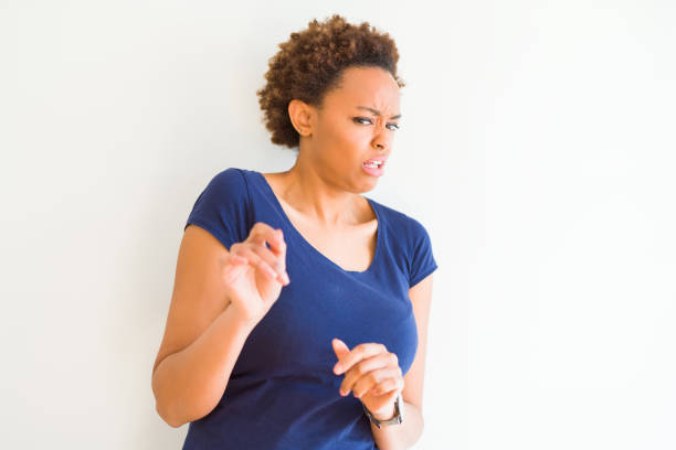 jeune belle femme américaine africaine au-dessus de l'expression de fond blanche dégoûtée, mécontente et craintive faisant le visage de dégoût parce que la réaction d'aversion. les mains levées. concept ennuyeux. - disgust women african ethnicity human face photos et images de collection