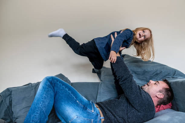 istock Father and daughter having fun on a sofa 1162421614