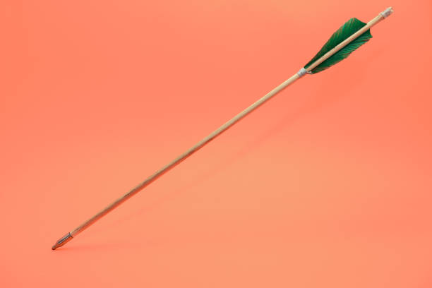 istock Old green wooden arrow on a beautiful peach background. 1162423652