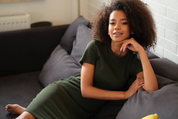 istock Nice afro-amercian woman with curly hair is chilling on the sofa. 1162425657