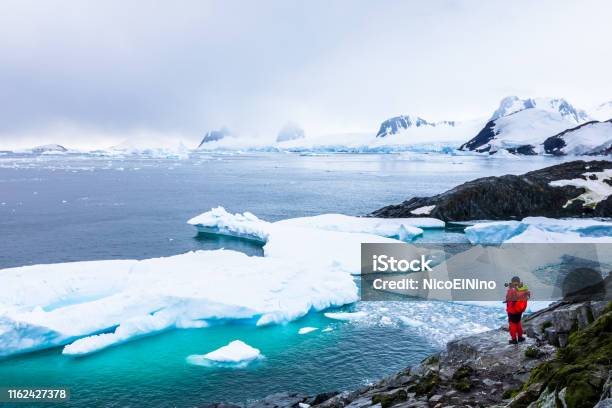 Tourist Taking Photos Of Amazing Frozen Landscape In Antarctica With Icebergs Snow Mountains And Glaciers Beautiful Nature In Antarctic Peninsula With Ice Stock Photo - Download Image Now