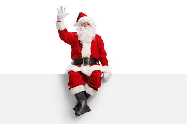 Santa claus sitting on a panel and waving Full length portrait of santa claus sitting on a panel and waving isolated on white background santa stock pictures, royalty-free photos & images