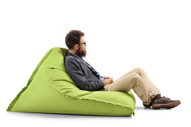 istock Bearded man sitting on a modern green bean bag chair 1162431616
