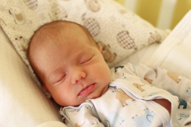 istock Cute newborn baby is sleeping on her bed. 1162431705
