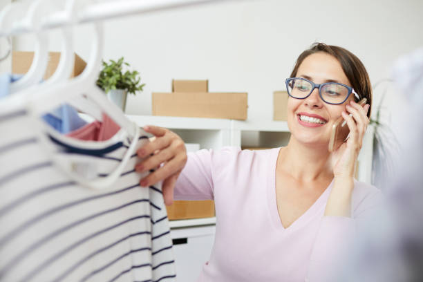 istock Young smiling woman looking at striped pullover on hanger 1162440276
