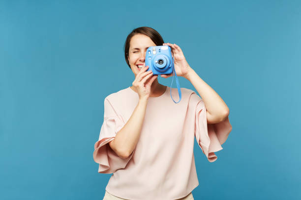 istock Young female photographer with blue camera 1162440353
