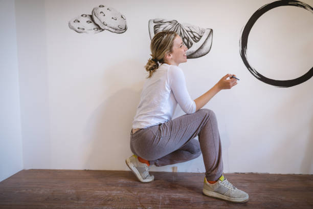 Innocent female mural artist crouching and smiling