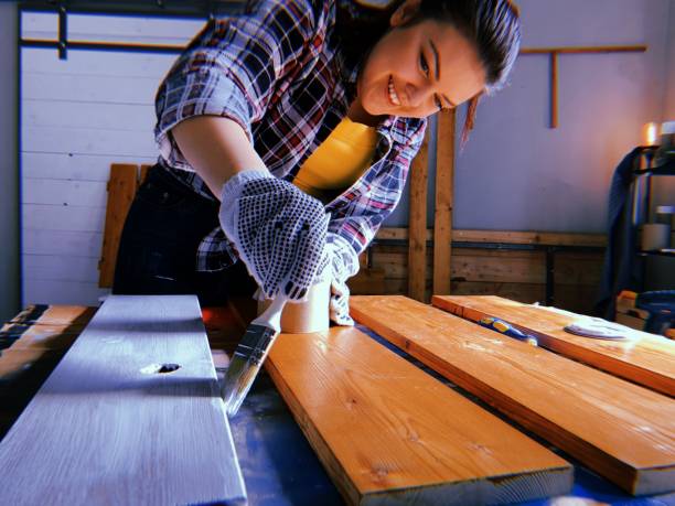 istock Woman painting plank in garage 1162445020