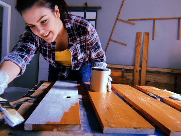 istock Woman painting plank in garage 1162445111