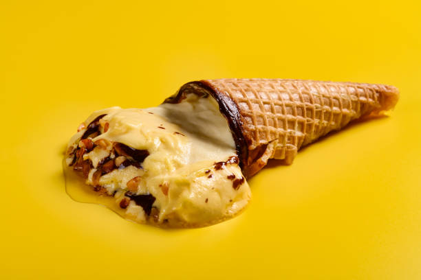 istock side view mango flavor ice cream cone with peanut melted on yellow background 1162452304