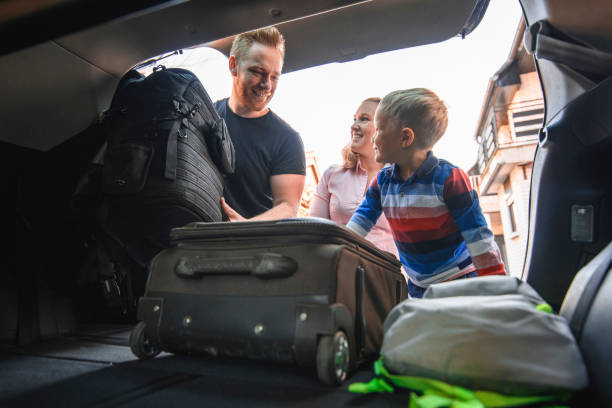istock Family packing backpacks and suitcases into a car trunk 1162453916
