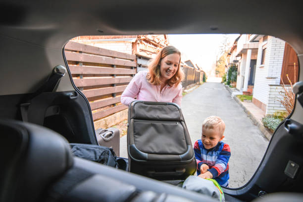 istock Mother and son packing backpacks and suitcases into a car trunk 1162453918
