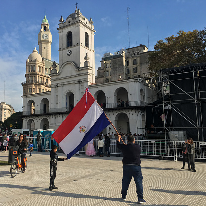 Buenos Aires, Argentina - June 2, 2019: Adult and boy holding paraguayan flag for a picture in Plaza de Mayo in the city downtown as part of an event organized by the city government dedicated to paraguayan culture and traditions as both countries have a huge bond between them