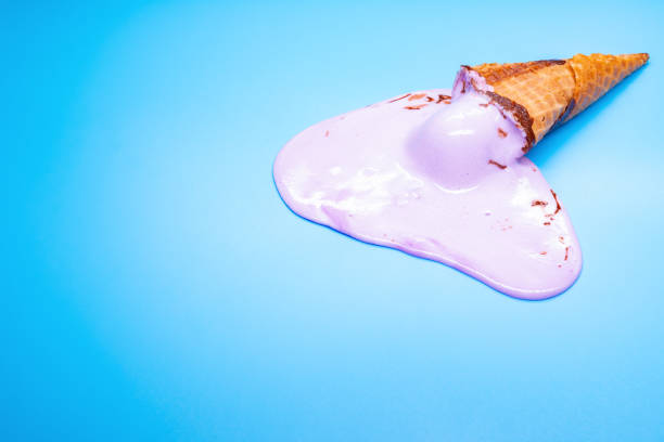 istock side view lilac ice cream cone in a melting process on blue background 1162456409