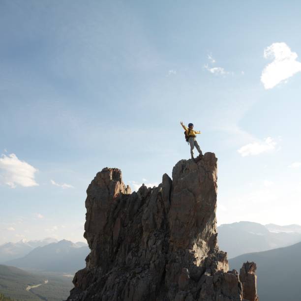 istock Mountaineer stands on summit of pinnacle 1162458861