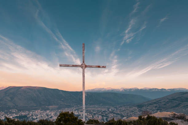wooden cross on a background of sunrise in the mountains