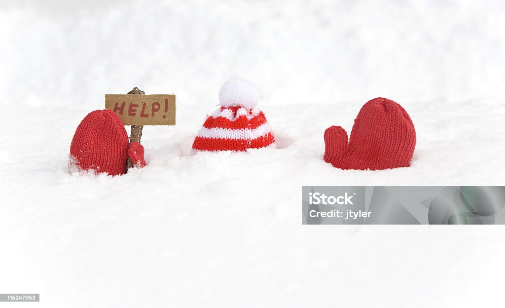 Buried in Snow A red hat and mitten sticking up from the snow with a help sign. Snow Stock Photo