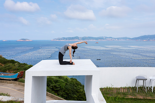 Healthy women exercising yoga outdoors.