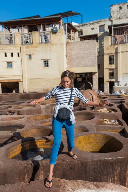 Workers  and dyeing in red hides in the vats of Fez tanneries, Morocco.