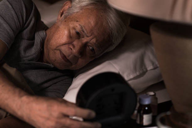 istock A depressed senior man lying in bed cannot sleep from insomnia looking at the alarm clock 1162477972
