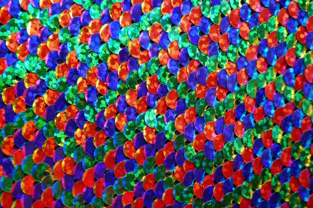 istock sequin pattern.Fish scales Sequin macro background in blue-green red tones .Shimmering sequins background 1162477991