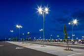 big modern empty parking lot with bright LED street lights at night