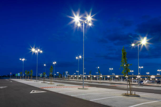 big modern empty parking lot with bright led street lights at night - street light parking lot night lot imagens e fotografias de stock