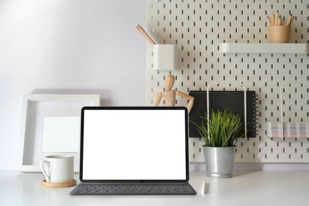 istock Home office desk with blank screen tablet with smart keyboard on minimal workspace table. 1162481326