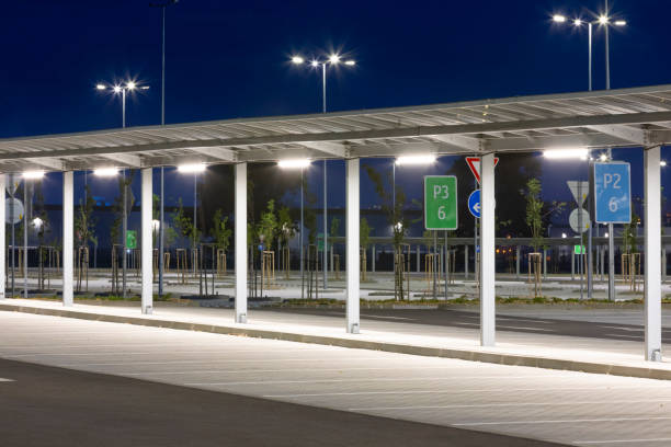 covered corridor for pedestrian in a modern parking lot at night with bright illumination - street light parking lot night lot imagens e fotografias de stock