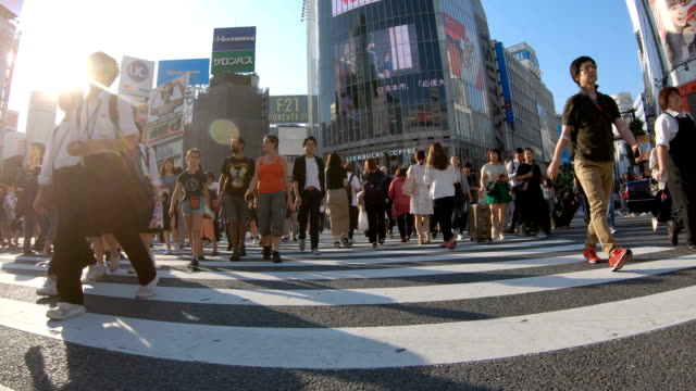 4K SLO MO Niedriger Winkel stabilisierte Handheld Menschen, die auf der Shibuya-Kreuzungsstraße laufen.