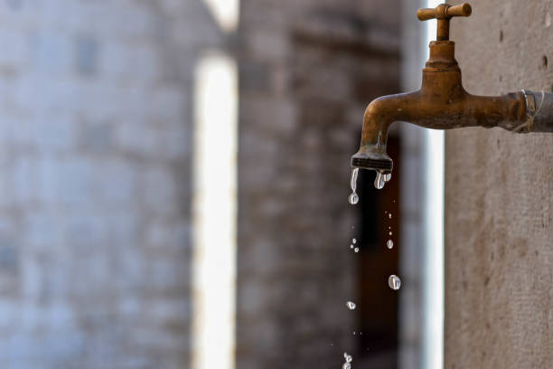 istock Closeup of rusty old faucet drips wasting water 1162489568