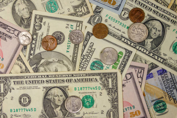 istock Background of different american dollars bills and coins 1162489699