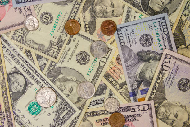 istock Background of different american dollars bills and coins 1162489850