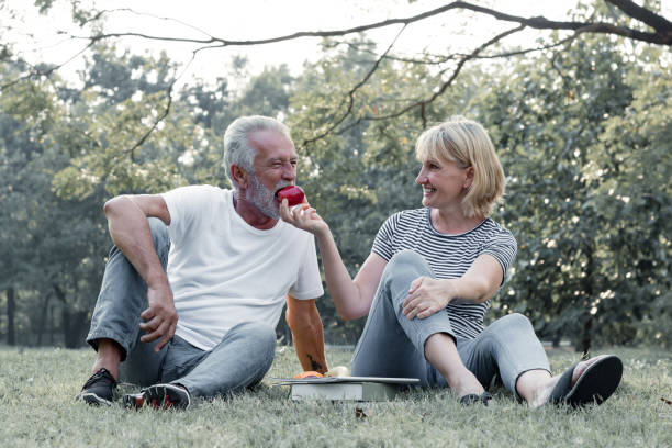 istock Couples senior give apples to each other together happily. 1162492475