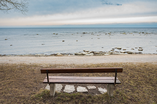 Picture of Lonely wooden bench on the autumn sea with cloudy sky