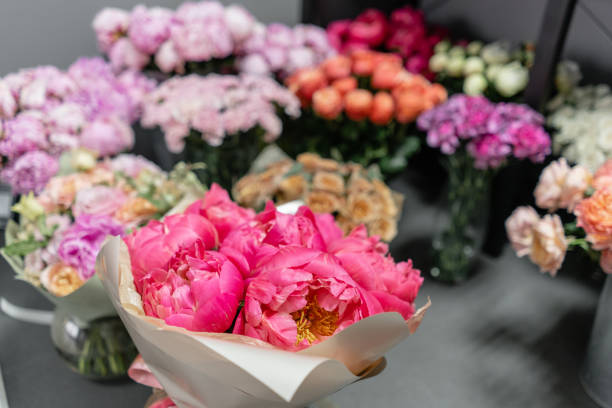 istock Vases with different colored flowers, showcase flower shop. Beautiful spring bouquets. . Small family business. Work florist. copy space 1162493812