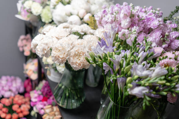 istock Vases with different colored flowers, showcase flower shop. Beautiful spring bouquets. . Small family business. Work florist. copy space 1162494492