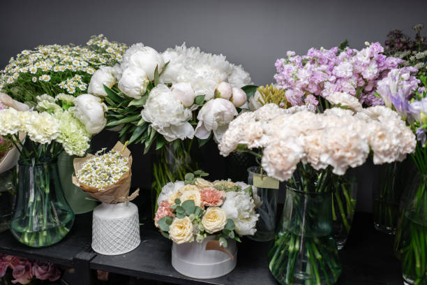 Vases with different colored flowers, showcase flower shop. Beautiful spring bouquets. . Small family business. Work florist. copy space