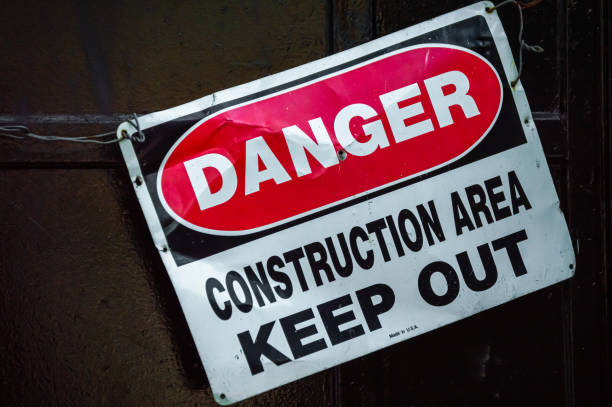 istock Crooked old metal warning sign that reads DANGER CONSTRUCTION AREA KEEP OUT. Graphic resource. 1162494605